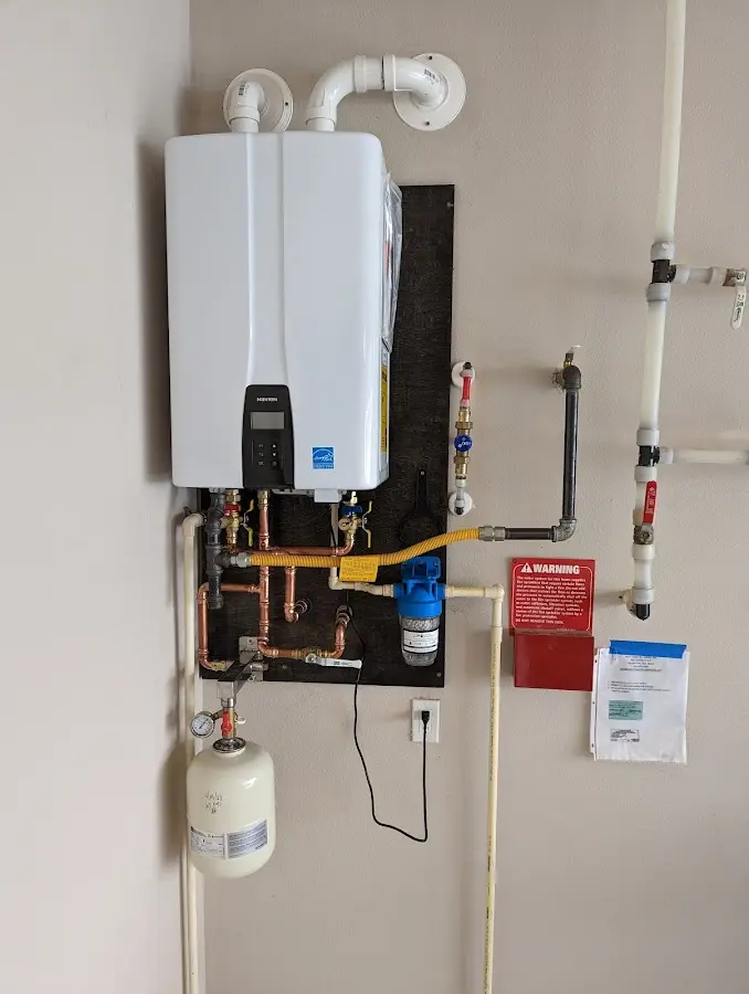 Professional plumber installing copper piping in a Walpole home